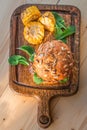 Delicious juicy Burger with a Golden crust is served on a wooden tray with grilled corn chips