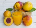 Delicious and juicy peach nectarina with glass of juice on white wooden table Royalty Free Stock Photo