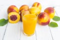 Delicious and juicy peach nectarina with glass of juice on white wooden table Royalty Free Stock Photo