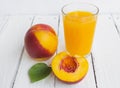 Delicious and juicy peach nectarina with glass of juice on white wooden table Royalty Free Stock Photo