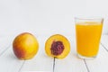 Delicious and juicy peach nectarina with glass of juice on white wooden table Royalty Free Stock Photo