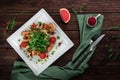 Delicious king prawn salad with tomatoes, arugula and grapefruit on a wooden table in a restaurant, top view