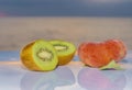 Delicious kiwi cut in half accompanied by a fresh flat peach Royalty Free Stock Photo