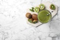 Delicious kiwi smoothie and fresh fruits on white marble table, top view. Space for text