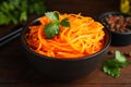 Delicious Korean carrot salad with parsley in bowl on wooden table, closeup