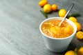 Delicious kumquat jam in bowl and fresh fruits on grey table, space for text Royalty Free Stock Photo