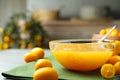 Delicious kumquat jam in bowl and fresh fruits on table, closeup. Space for text Royalty Free Stock Photo