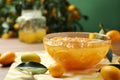 Delicious kumquat jam in bowl and fresh fruits on table, space for text Royalty Free Stock Photo