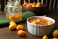 Delicious kumquat jam in bowl and fresh fruits on wooden table Royalty Free Stock Photo
