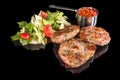 Delicious lamb meatballs served with fresh salad and mashed tomatoes with reflection,