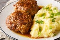 Delicious large meatballs with gravy with a side dish of mashed potatoes close-up in a plate. Horizontal