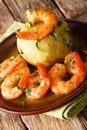 Delicious latino American Mofongo from bananas and chicharron served with shrimp and broth close-up on the table. vertical