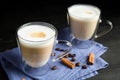 Delicious latte macchiato, cinnamon and coffee beans on table Royalty Free Stock Photo