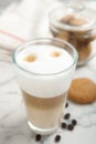 Delicious latte macchiato, cookies and coffee beans on white marble table Royalty Free Stock Photo