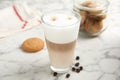 Delicious latte macchiato, cookies and coffee beans on white marble table Royalty Free Stock Photo