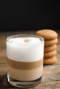 Delicious latte macchiato and cookies on wooden table Royalty Free Stock Photo