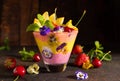 Delicious layered berry and fruit smoothie with edible flowers. Healthy dessert. Clean eating