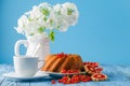 Delicious lemon cake on blue background with berries and flowers Royalty Free Stock Photo