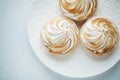 Delicious lemon tartlets with meringue on a white vintage plate. Sweet treat on a light blue background. Flat lay and copy space. Royalty Free Stock Photo