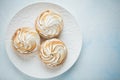 Delicious lemon tartlets with meringue on a white vintage plate. Sweet treat on a light blue background. Flat lay and Royalty Free Stock Photo