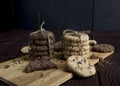 Delicious light and dark cookies, stacked and tied with a string on a wooden background.