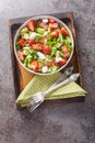 Delicious light salad of strawberries, avocado, bacon, lettuce, feta cheese close-up in a bowl. Vertical top view Royalty Free Stock Photo