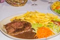 Beef with fried potatoes and salad on a plate. Royalty Free Stock Photo