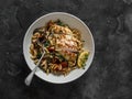 Delicious lunch - orzo with mushrooms, dried tomatoes, spinach and lemon thyme chicken breast on a dark background, top view Royalty Free Stock Photo