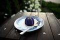 Delicious luxury raw vegan dessert served on a plate with fork on a wooden table on summer terrace of a cozy cafeteria