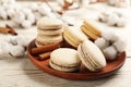 Delicious macarons and cotton flowers on white wooden table
