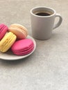 Delicious macaroons and cup of coffee on gray table