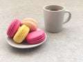 Delicious macaroons and cup of coffee on gray table