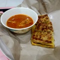 delicious Malaysian cuisine called murtabak or meat puff with spicy chicken curry in a white bowl