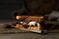 Delicious marshmallow sandwich with bread and chocolate on wooden table, closeup