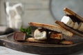 Delicious marshmallow sandwiches with chocolate on white wooden table, closeup