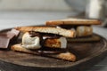 Delicious marshmallow sandwiches with chocolate on wooden tray, closeup