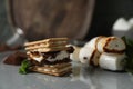 Delicious marshmallow sandwiches with crackers and chocolate on grey plate, closeup