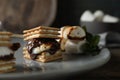 Delicious marshmallow sandwiches with crackers and chocolate on grey plate, closeup