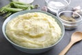 Delicious mashed potatoes in the bowl,peas, spices,garlic on the grey table Royalty Free Stock Photo