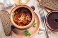 Delicious meat roast with vegetables and cheese on wooden in clay pot rustic table. Meal served for the lunch. Close up top view Royalty Free Stock Photo