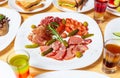 Delicious meat snacks for wine party.Gourmet snack dish with sliced Spanish jamon,pepperoni sausages,beef ham and pickled Royalty Free Stock Photo