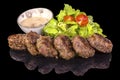 Delicious meatballs served with fresh salad and sauce with reflection