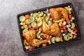 Delicious Mediterranean baked chicken legs with vegetables and feta cheese close-up on a baking sheet on the table. Horizontal top Royalty Free Stock Photo