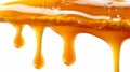 Delicious melted caramel sauce dripping drops isolated on a clear white background