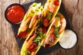 Delicious Mexican tacos with shrimps and vegetables close-up served with sauces. horizontal top view Royalty Free Stock Photo