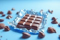 Delicious milk chocolate bar wrapped in foil on a blue background Ai photo Royalty Free Stock Photo