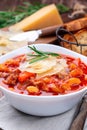 Delicious minestrone soup served with crispy bread, on wooden background, vertical Royalty Free Stock Photo