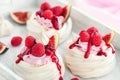 Delicious mini Pavlova meringue cake decorated with fresh raspberry, figs and berry sauce Royalty Free Stock Photo