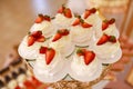 Delicious mini Pavlova meringue cakes with fresh strawberry on gold festive tray Royalty Free Stock Photo