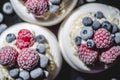 Delicious mini pavlova meringue desserts served with frozen frosty berries and mascarpone whipped cheese